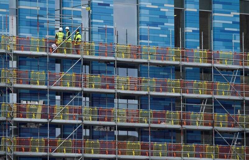 Workers Stand On Scaffolding At A Residential Building In London