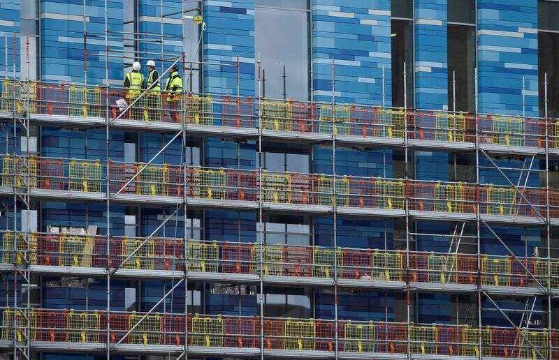 Workers Stand On Scaffolding At A Residential Building In London